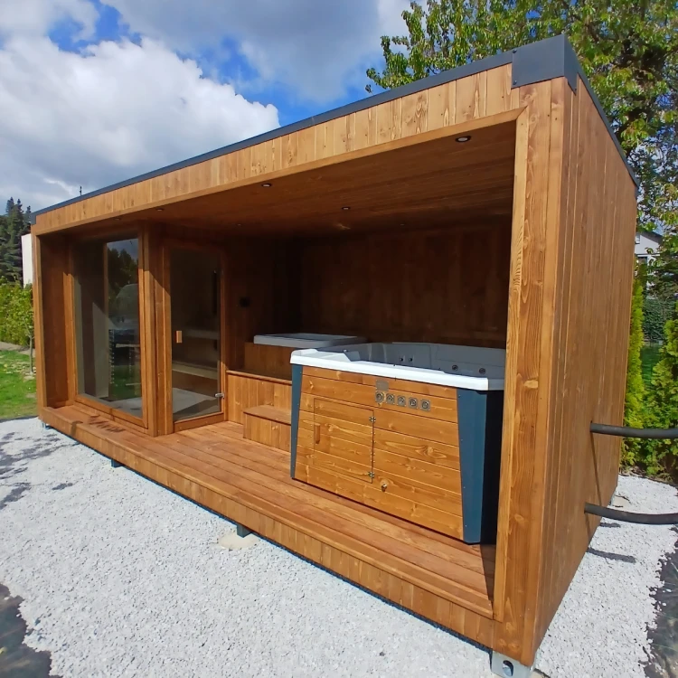 Nowoczesna całoroczna sauna ogrodowa o wymiarach 6 x 2,5 m połączona z zadaszoną strefą relaksu, wbudowanym jacuzzi oraz banią do morsowania