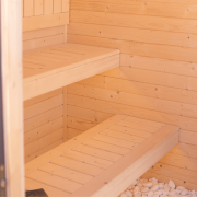 Jasne wnętrze sauny z ławkami świerkowymi i ergonomicznym układem
